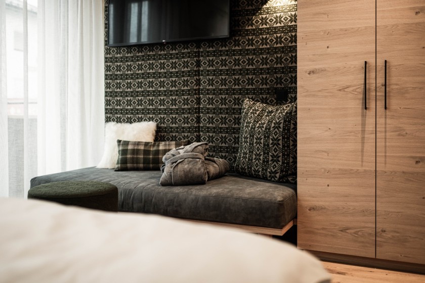 Cosy seating area with alpine design elements and beautiful patterns with cosy bathrobes on top