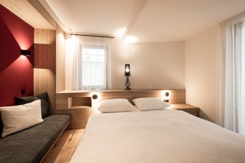 Modernes Schlafzimmer mit gemütlicher Sitzecke und Doppelbett