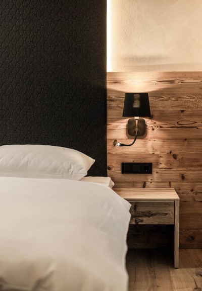 cosy bed with beautiful old wood bedside tables and alpine flair