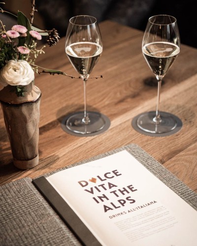 Table with two champagne glasses and our drinks menu